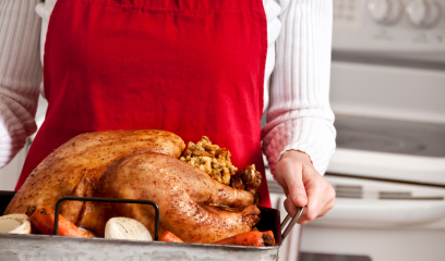 Cook holding tray with cooked turkey on it