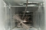 A duct being cleaned with a high pressure brush.