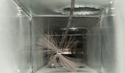 A duct being cleaned with a high pressure brush.