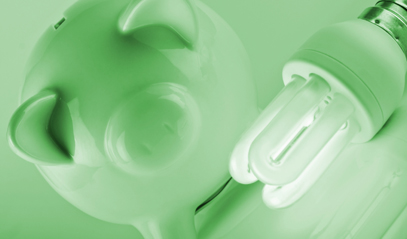 green-hued picture of piggy bank with energy efficient light bulb