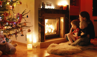 Young mother and her daughters by a fireplace