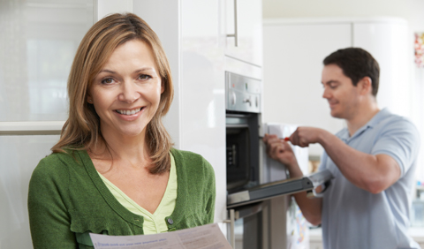 woman smiling as workman installs new stove